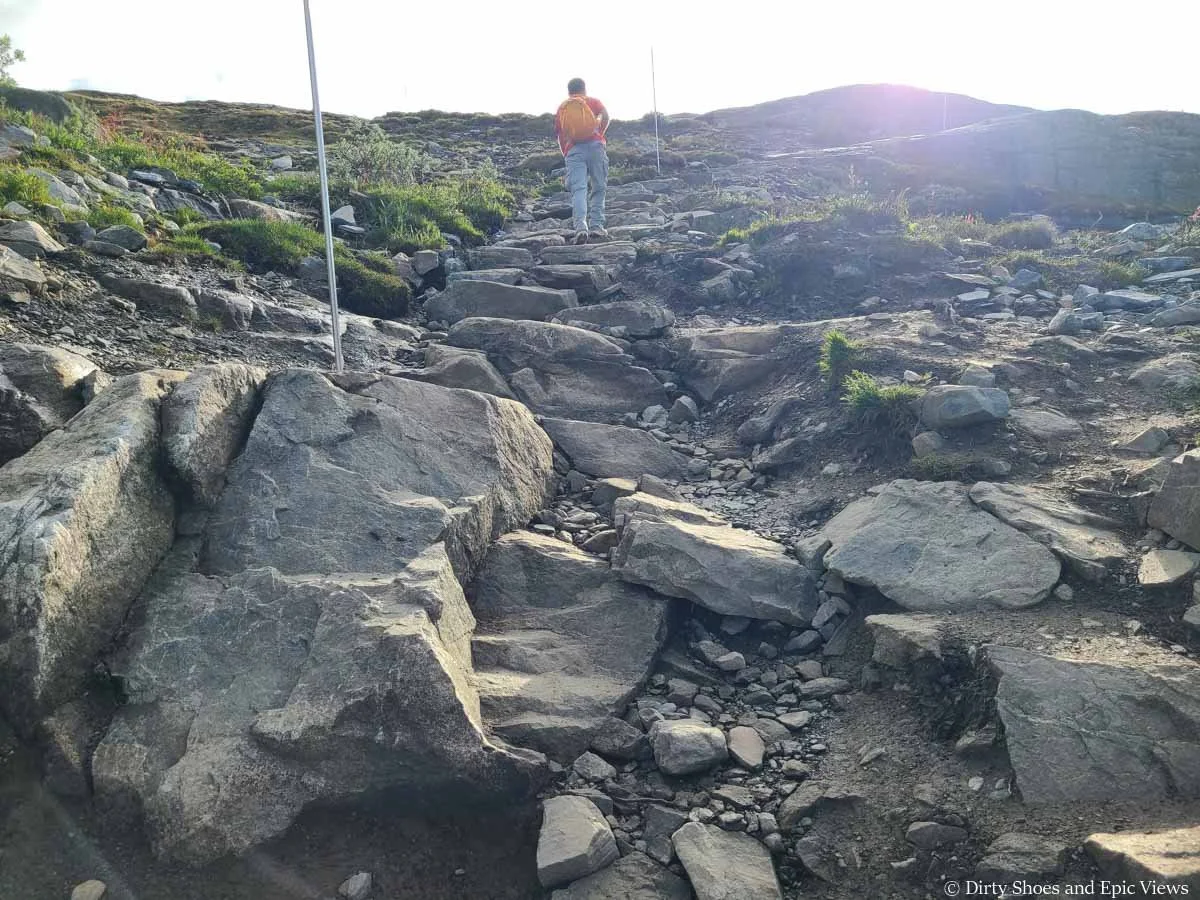 A hiker ascends a stone staircase on the Trolltunga hike