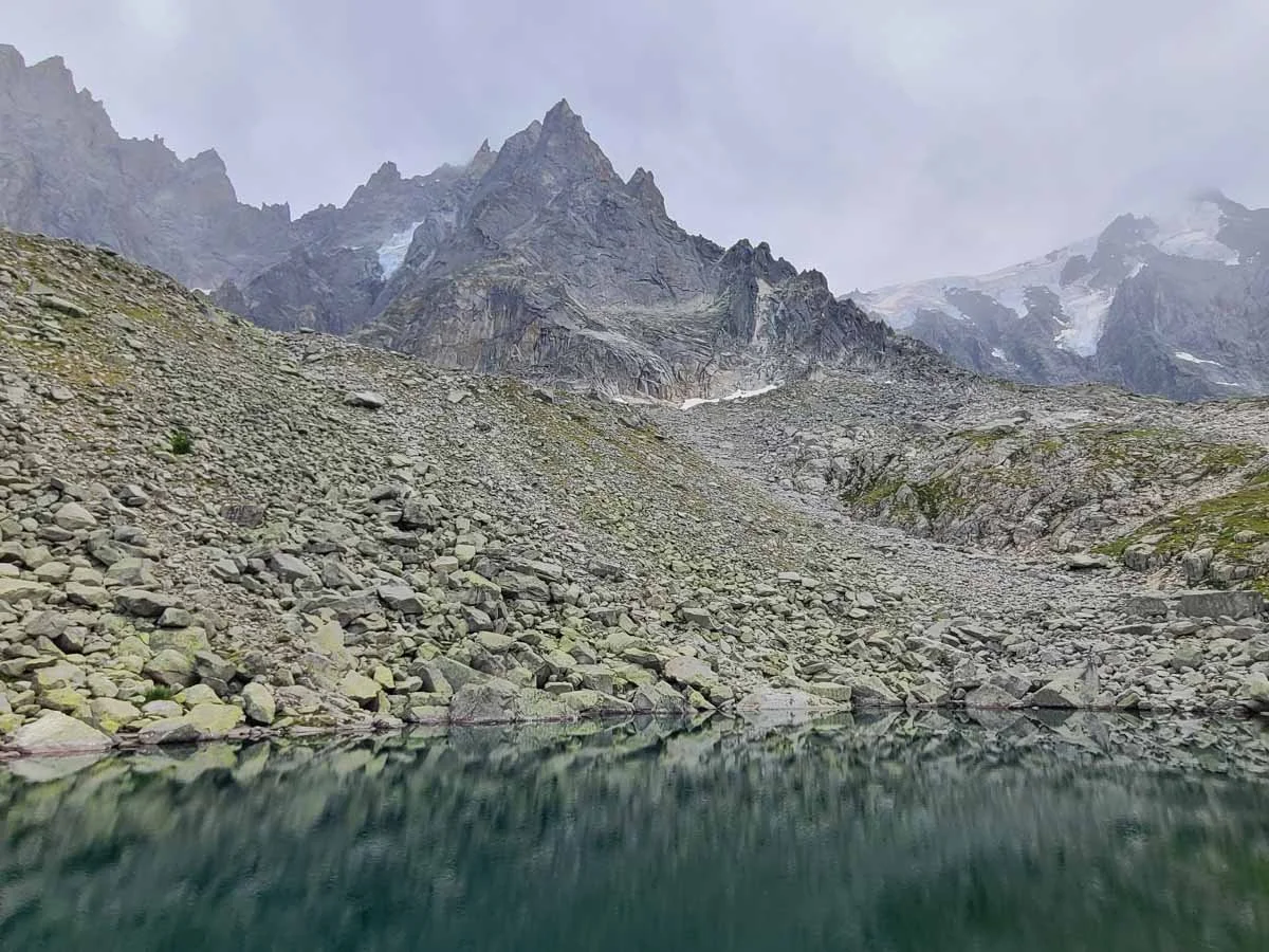 A blue lake sits beneath rocky peaks in Chamonix