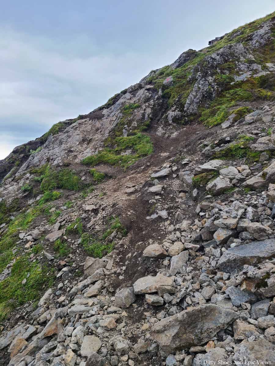 A slick steep path full of loose rock is found along the Reinanuten trail in Norway