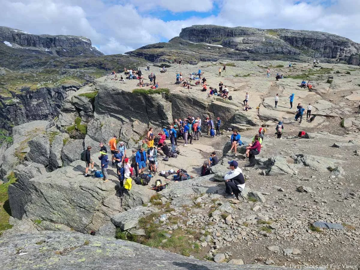 A crowd forms on a rocky cliff edge near Trolltunga in Norway