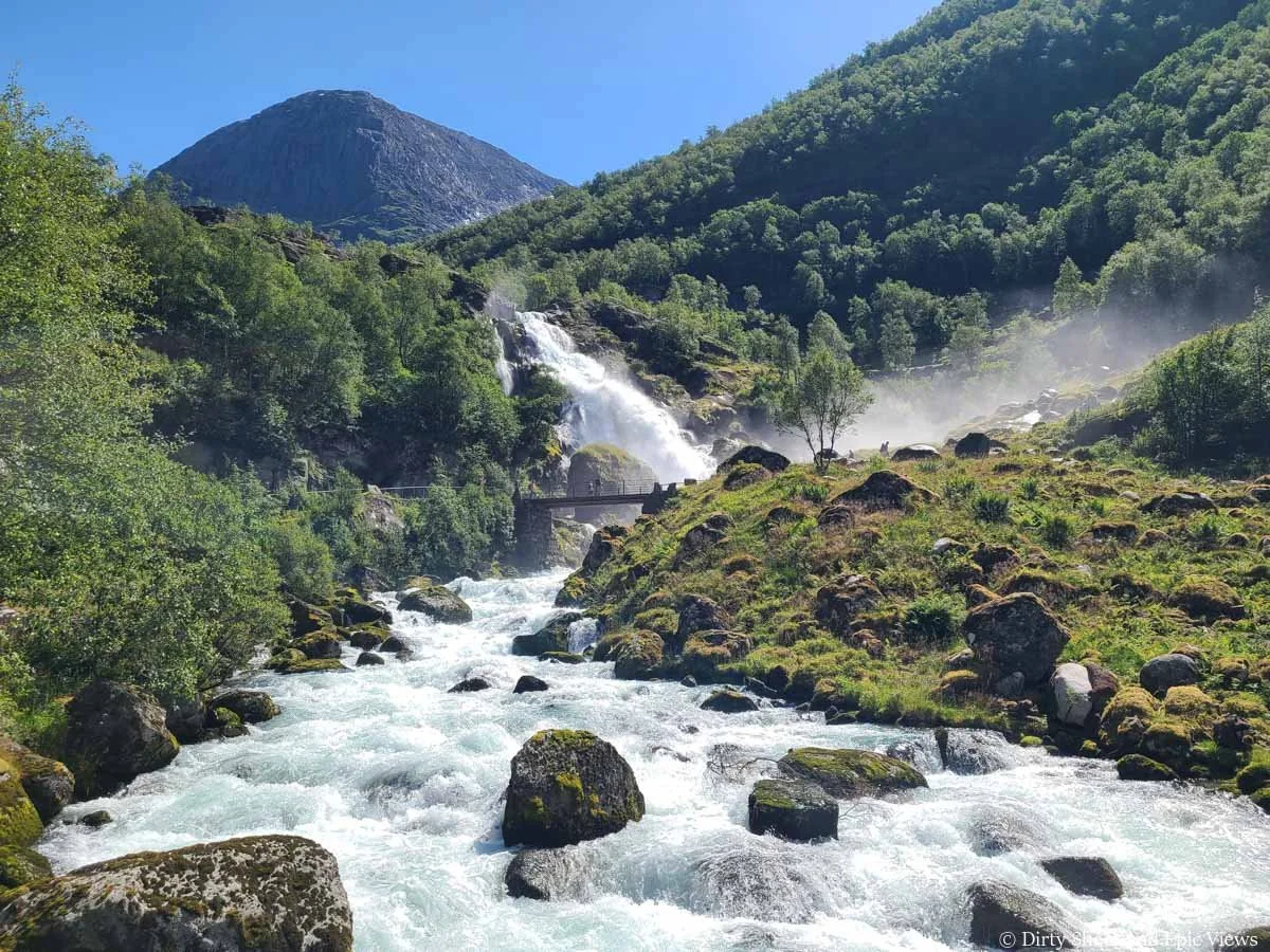 A stream leads to a powerful waterfall in the distance along the Briksdalsbreen hike in Norway