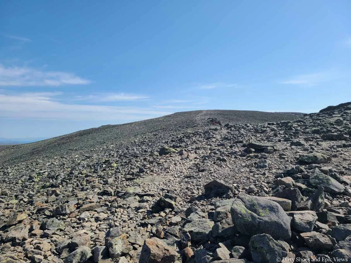 A faint herd path ascends up a rocky landscape on the Besseggen Ridge trail in Norway