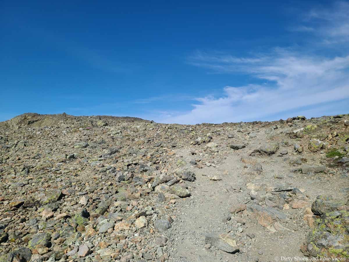A faint herd path crosses a rocky landscape on the Besseggen Ridge trail in Norway
