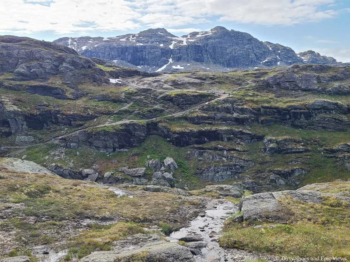 A trail weaves up a steep cliffside on the Trolltunga hike