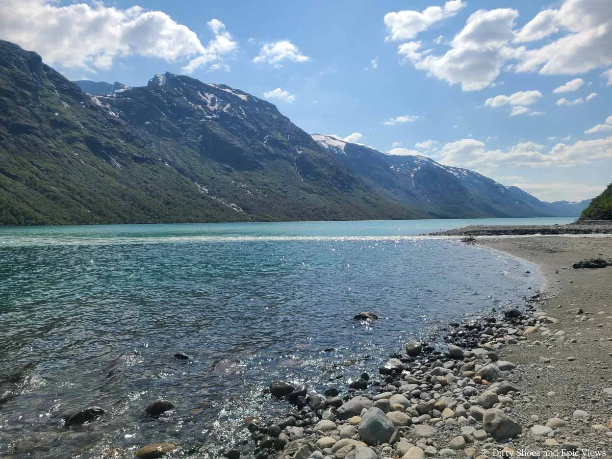 Jagged peaks rise above a clear blue lake at the Besseggen Ridge trailhead