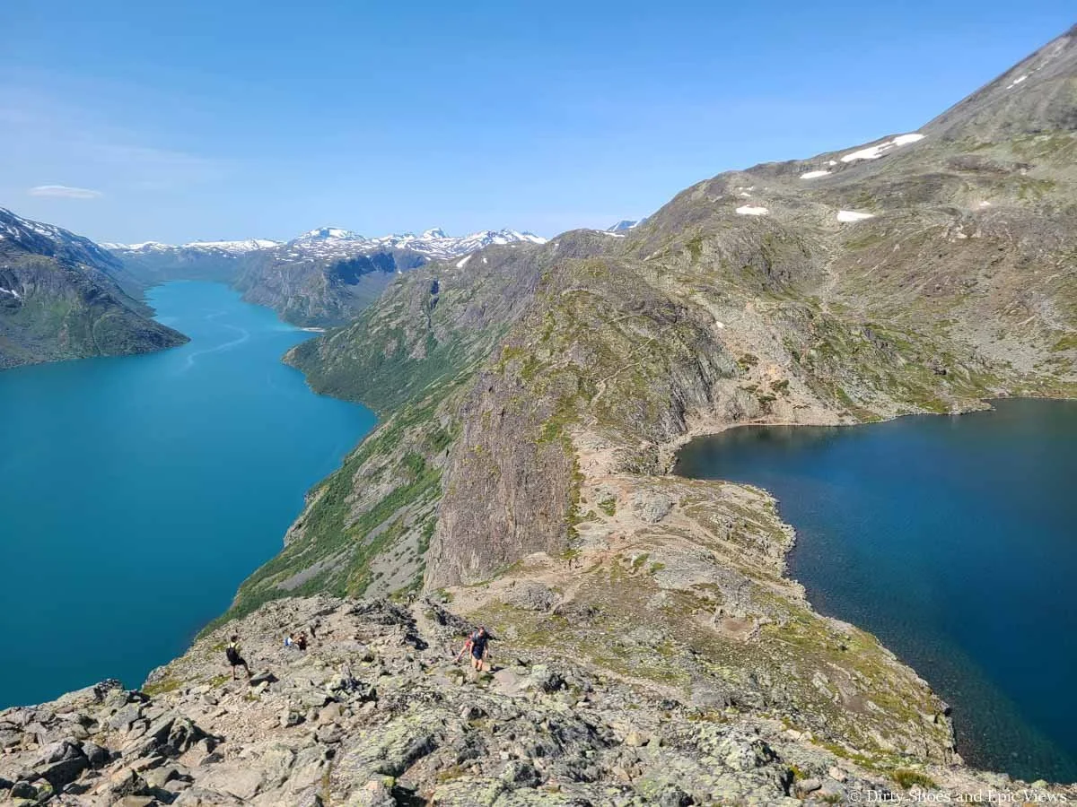 Looking down on hikers ascending a rocky ridge on the Besseggen Ridge trail in Norway