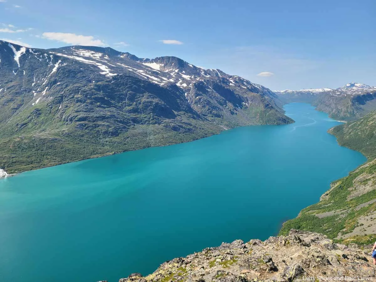 Mountains rise above a turquoise lake along Besseggen Ridge in Norway