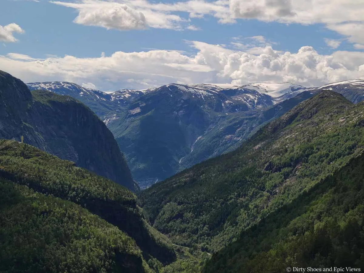 Snowcapped mountains backdrop a forested valley near Trolltunga