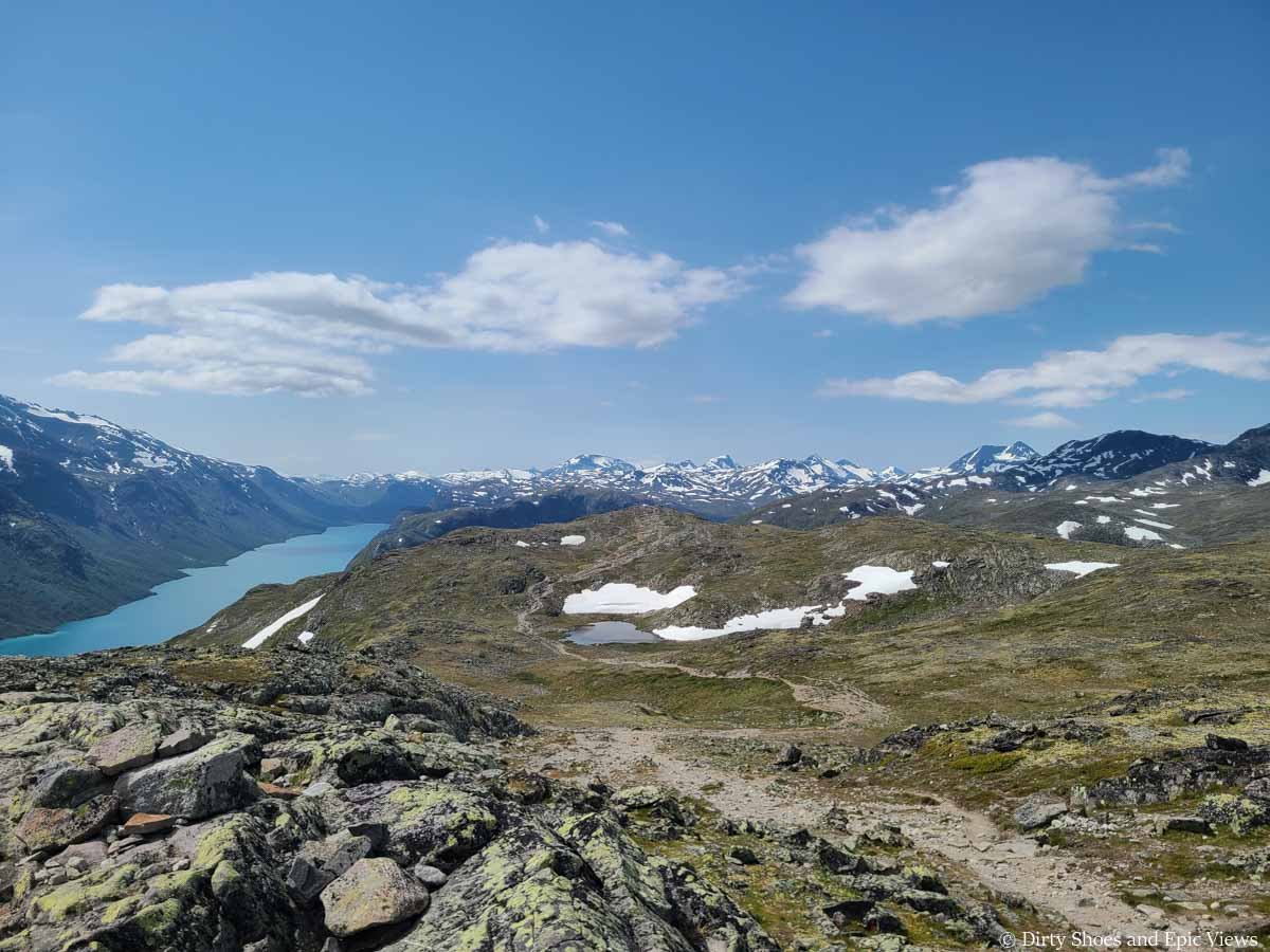 A herd path travels across a grassy mountain plateau on the Besseggen Ridge Trail in Norway