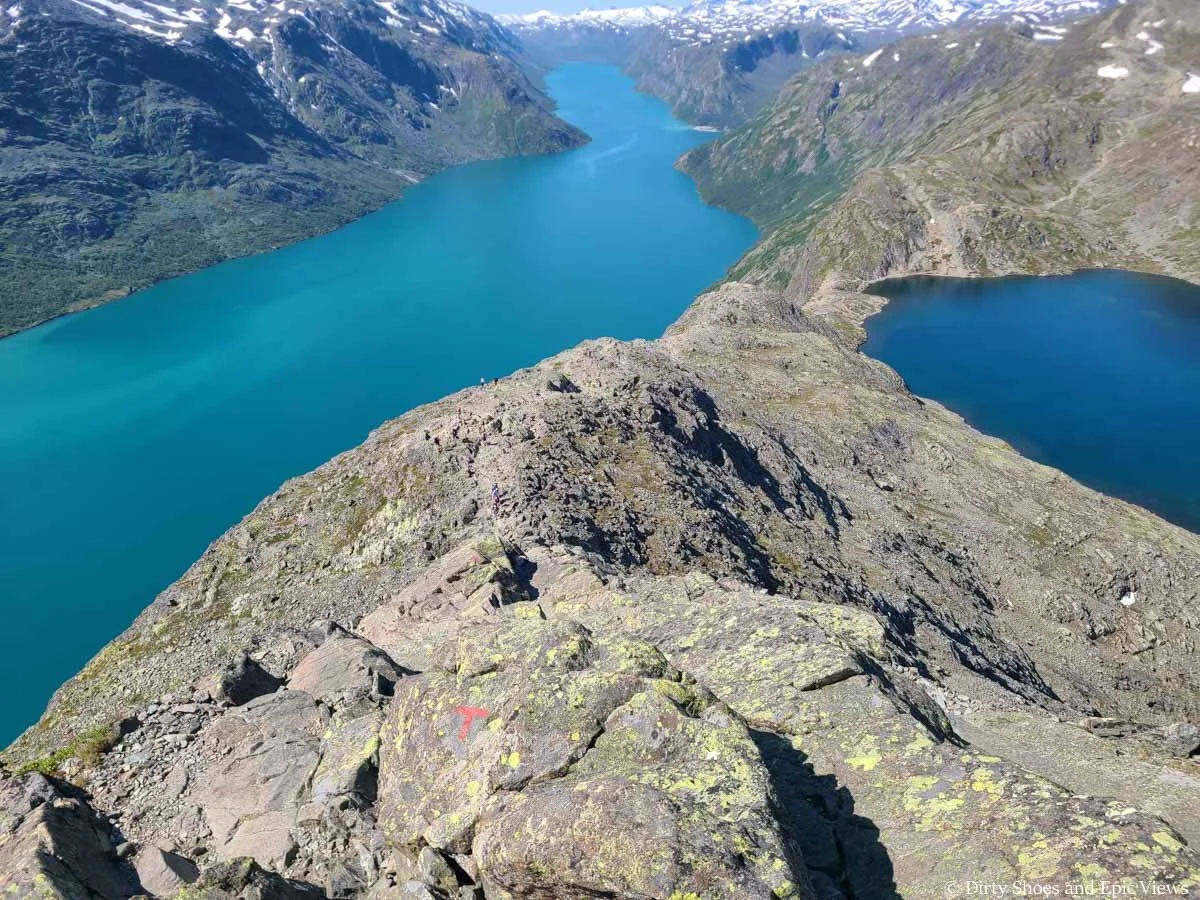 A narrow rocky ridge descends down between two blue lakes on the Besseggen Ridge hike in Norway