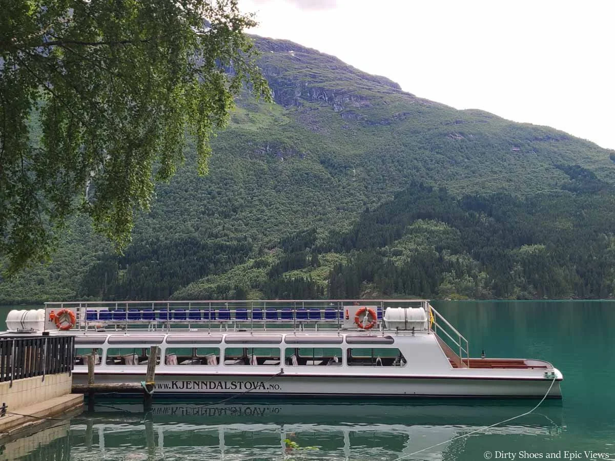 a tour boat sits at a dock on Lovatnet in Norway