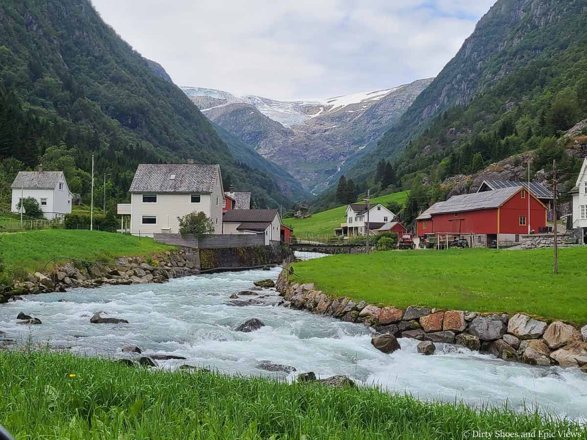 A stream runs through a quaint valley towards a glacier view in Buerdalen Valley of Norway