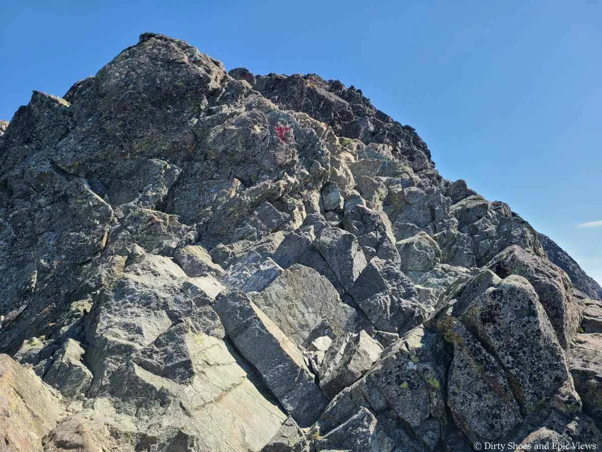 A red T marks a trail through a steep rocky ascent along the Besseggen Ridge Trail in Norway