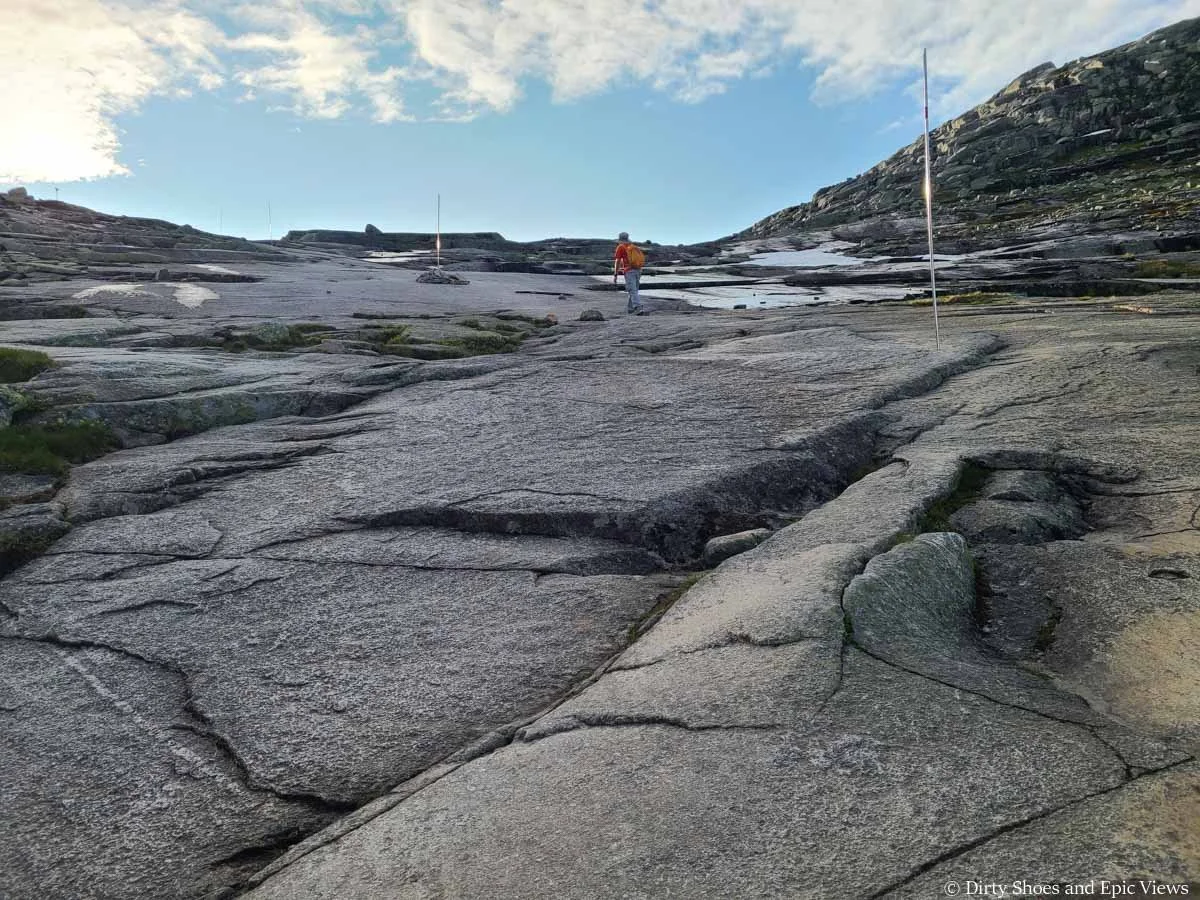 A hiker ascends steep slab on the pass towards Trolltunga in Norway