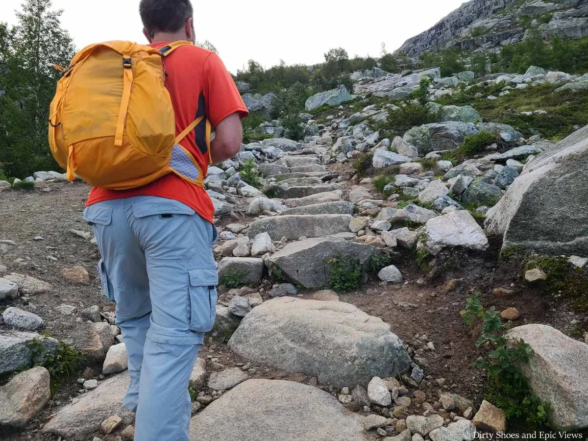 A hiker looks up a series of steep stone steps on the Trolltunga hike