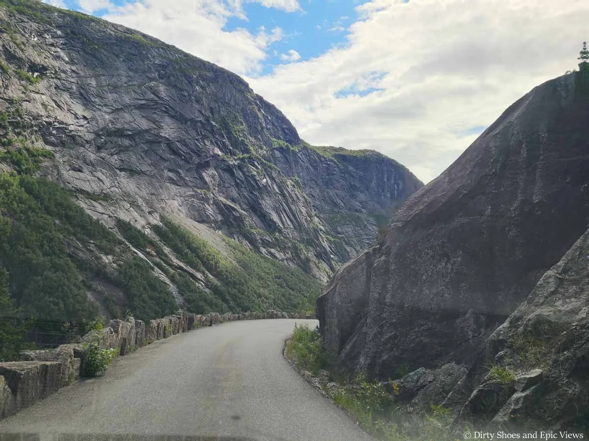 A blind turn rounds a corner by a rocky cliff on the way to Trolltunga in Norway