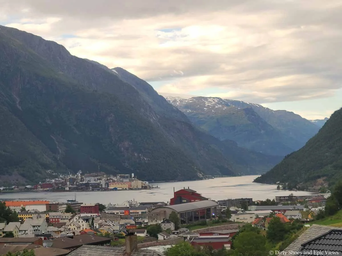 A town sits at the edge of a fjord surrounded by mountains in Odda Norway near Trolltunga