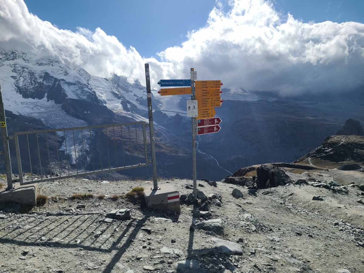 Trail signs point in different directions on the hike to Riffelsee in Zermatt