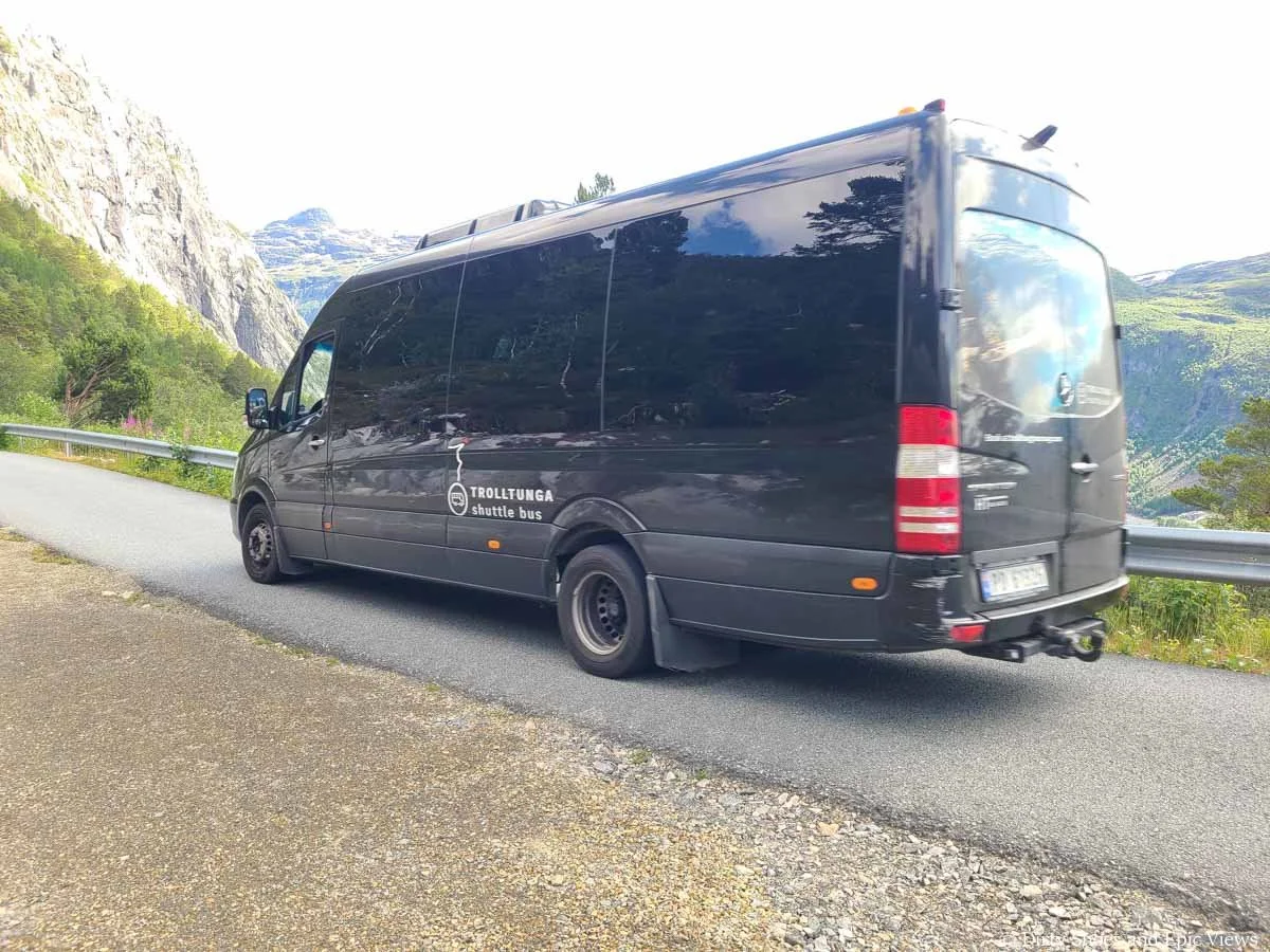 A large passenger van travels a narrow road to get to the Trolltunga trailhead in Norway