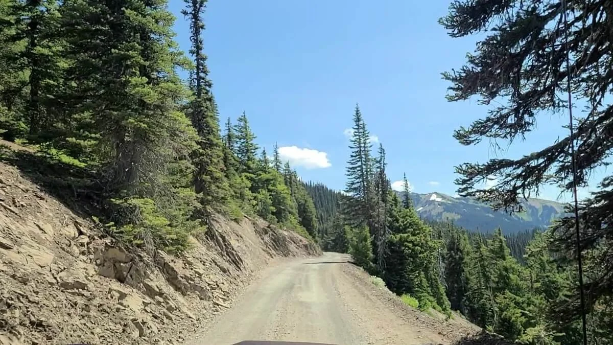 A narrow dirt road with exposure and a blind turn ahead