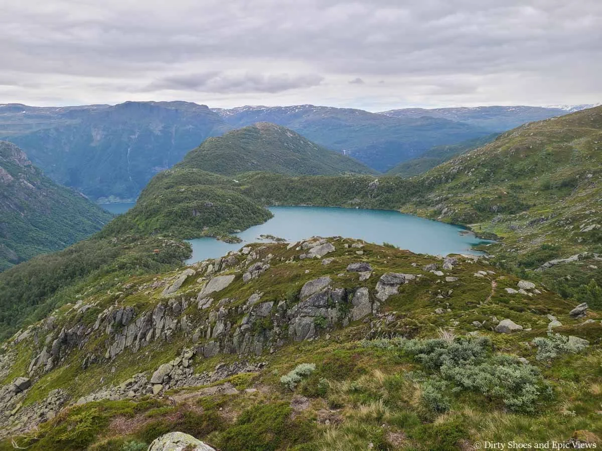 A high elevation mountain lake sites above views of mountains and valleys along the Reinanuten trail in Norway