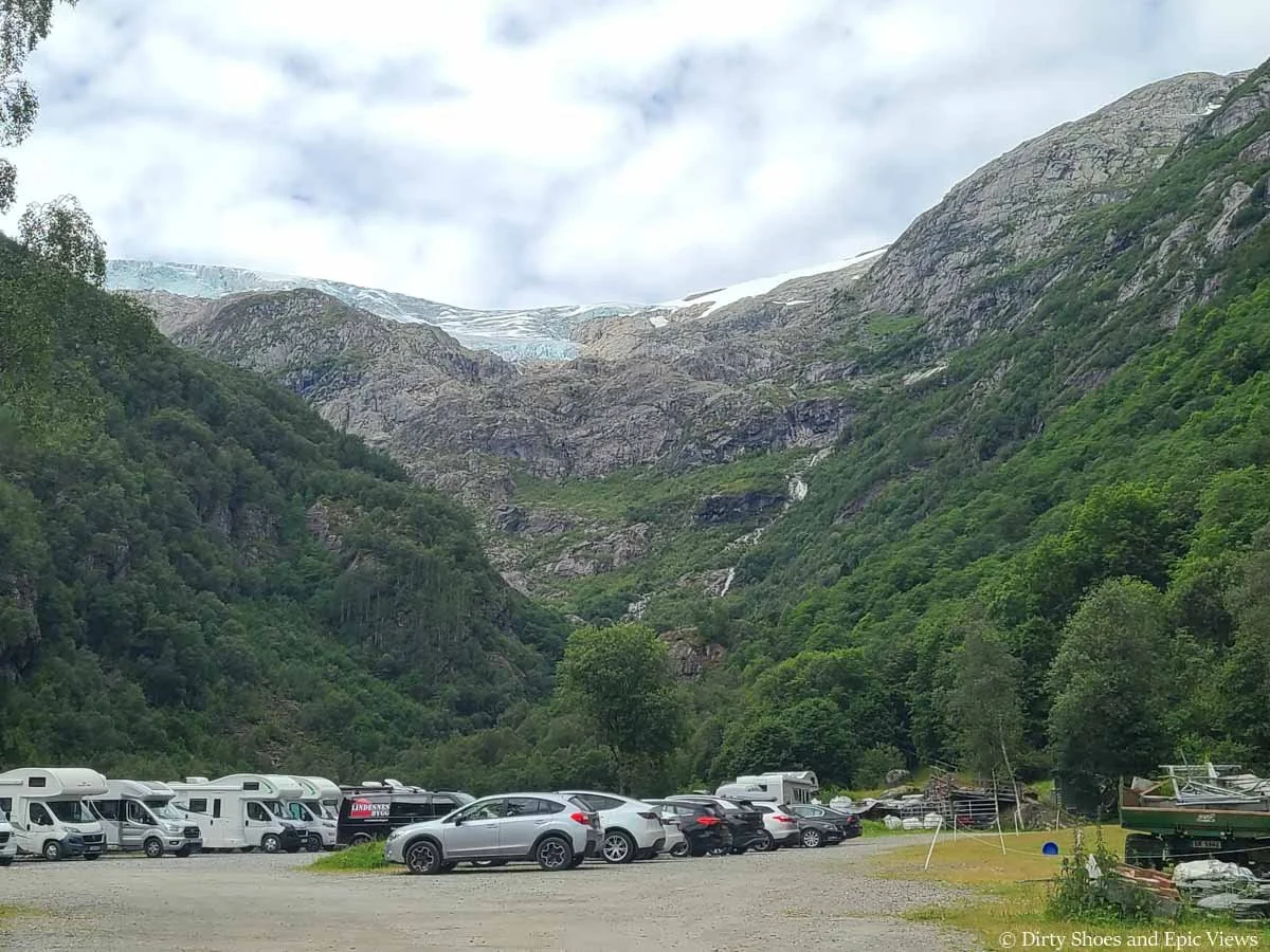 A large parking area beneath mountain views for the Reinanuten trailhead in Norway