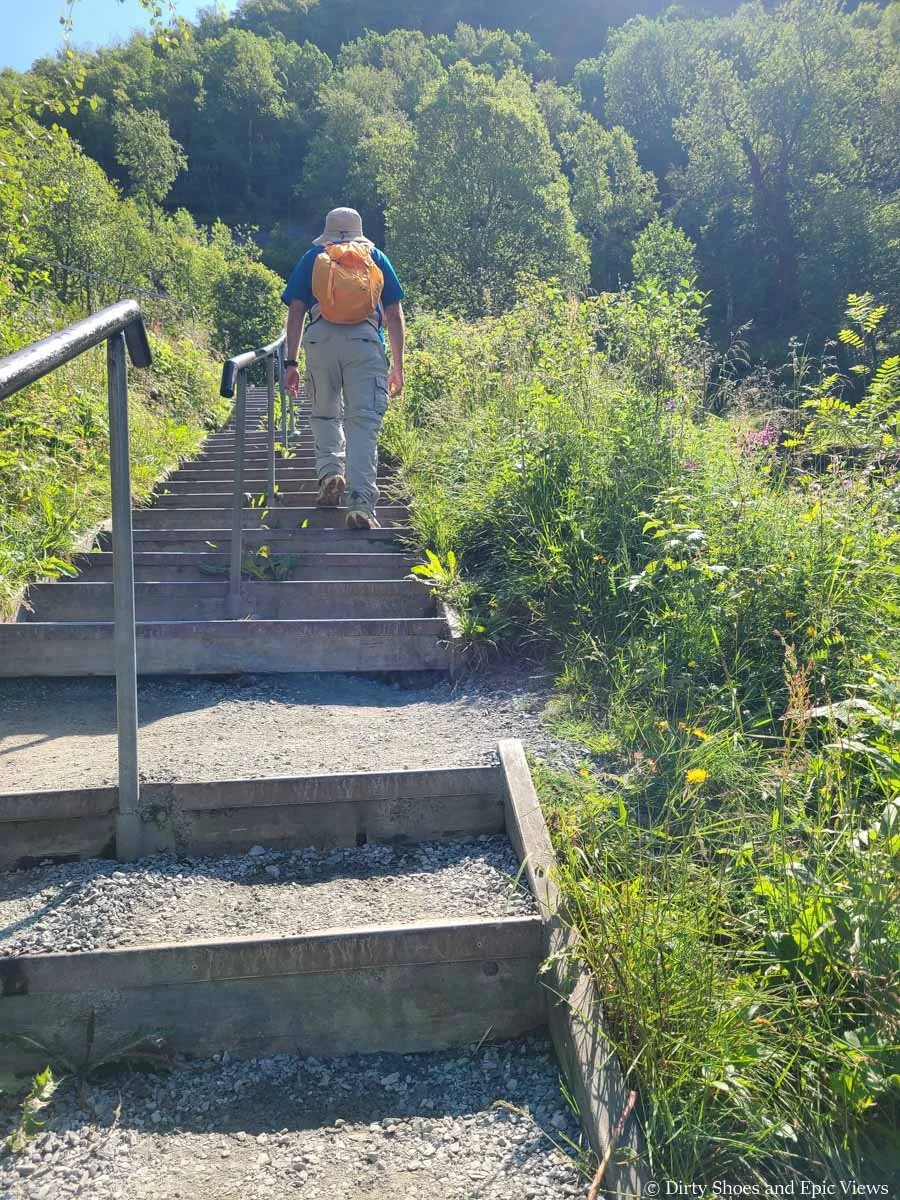 A hiker ascends a long staircase on the Briksdalsbreen hike