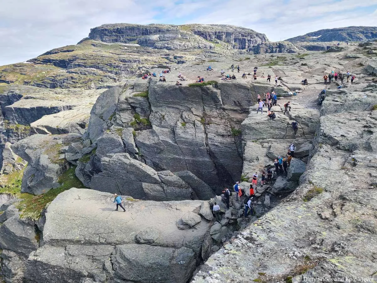 A crowd forms at the edge of a cliff near Trolltunga