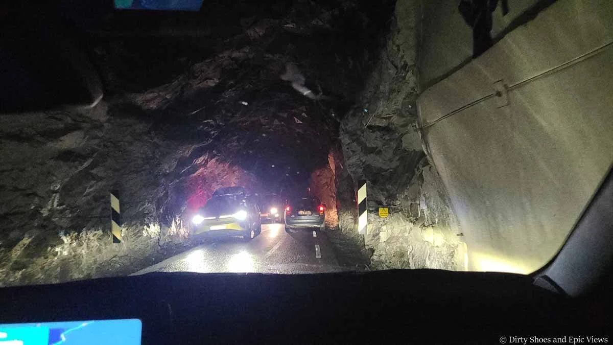 Cars bypass eachother on a narrow road in a rock tunnel on the way to Austerdalsbreen