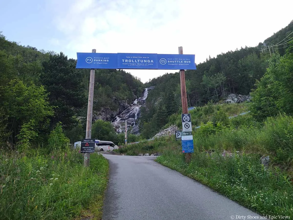 A blue sign marks the start of the hike to Trolltunga and the line for the shuttles to the Trolltunga trailhead