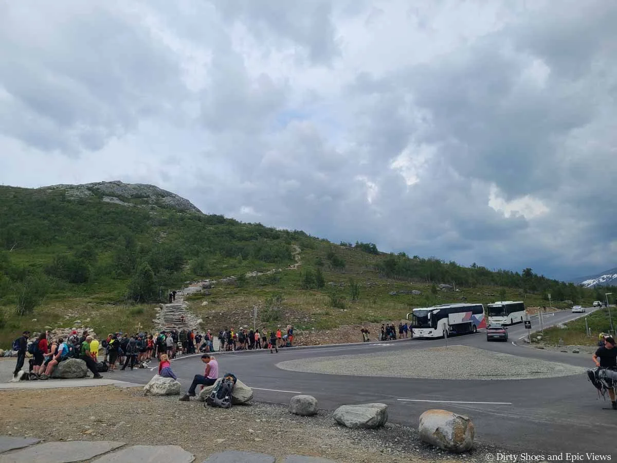 A line of hikers wait to get on a pair of buses at the end of the Besseggen Ridge hike