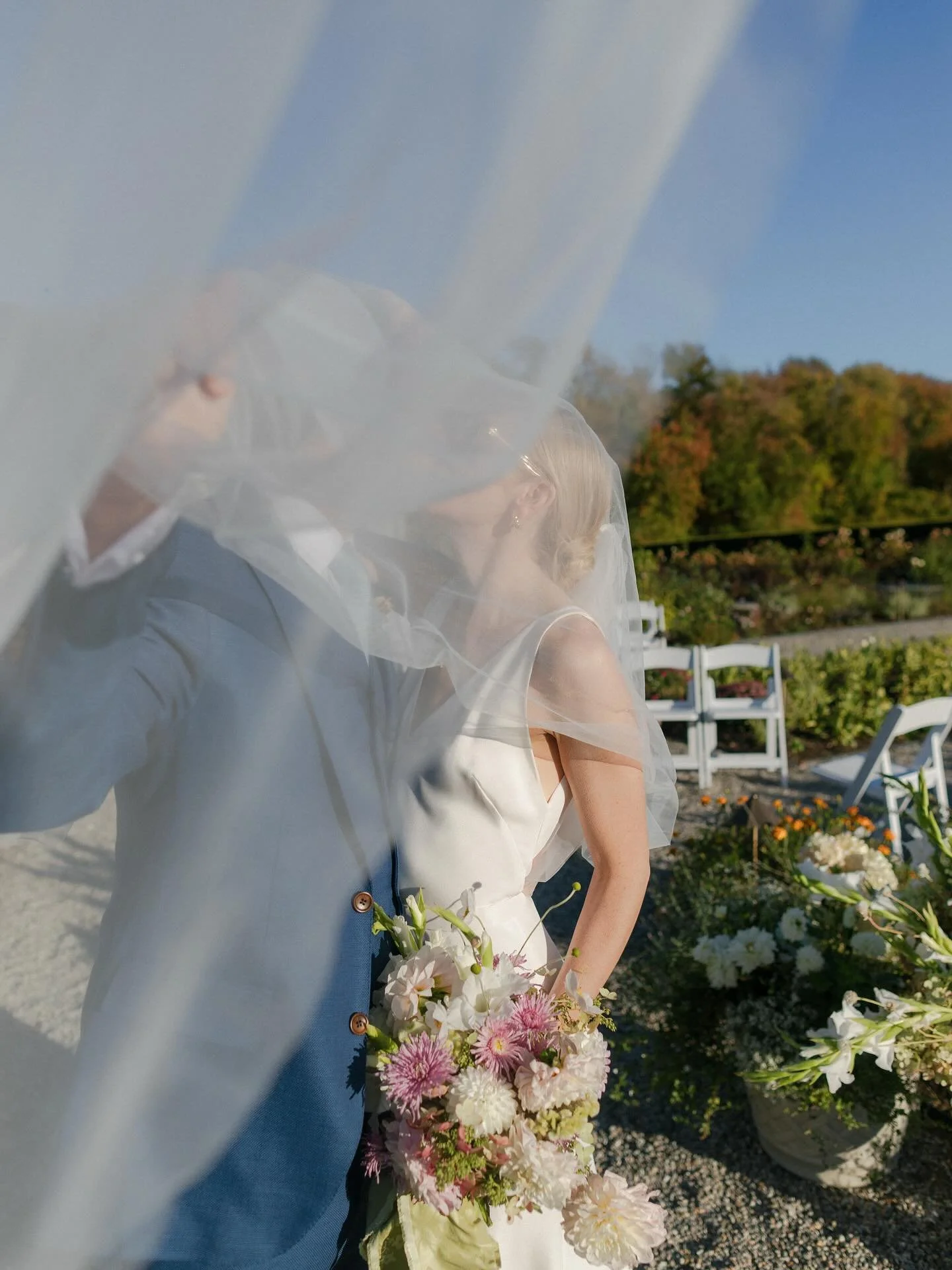 The story retold as a collection of moments &mdash; a hand taming the bride&rsquo;s veil, a mother smoothing a sleeve, the quiet interplay of silk and sunlight.

Grapes looking harvested fresh from the vine, ribbon-tied menus awaiting guests, warm pe