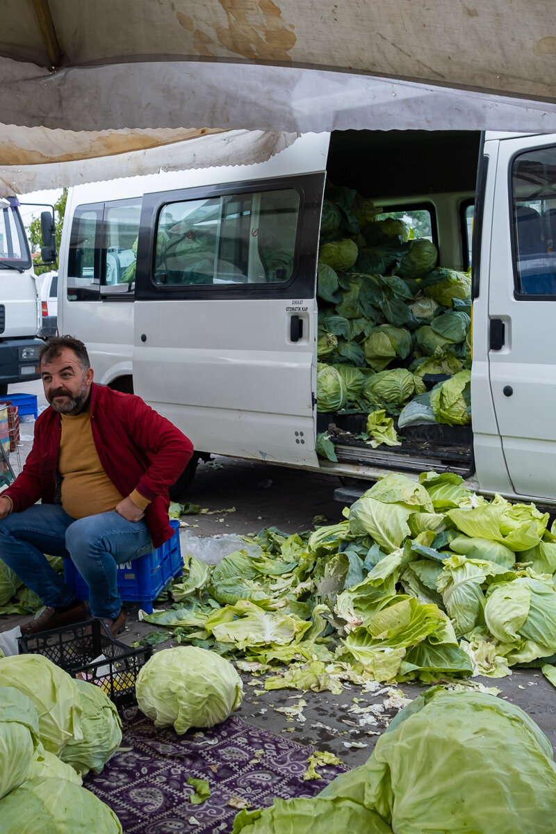 A local market vendor proudly shows off his harvest.