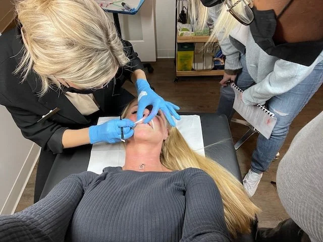 Brittany demonstrating lip blush technique during a permanent makeup training session in Calgary