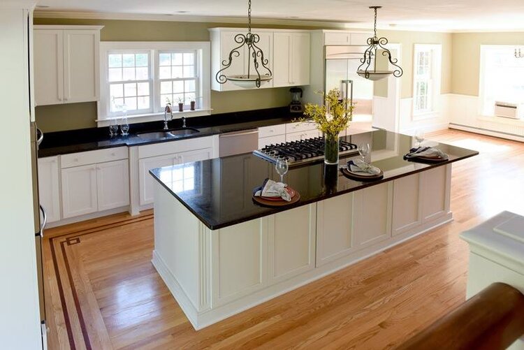large kitchen island with dark counter tops and white cabinets