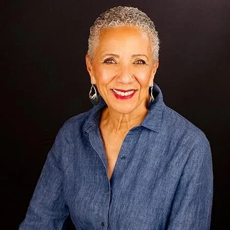 Woman with short hair wearing a blue denim button up shirt and red lipstick