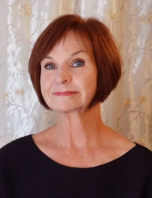 Woman with chin length red hair wearing a black shirt