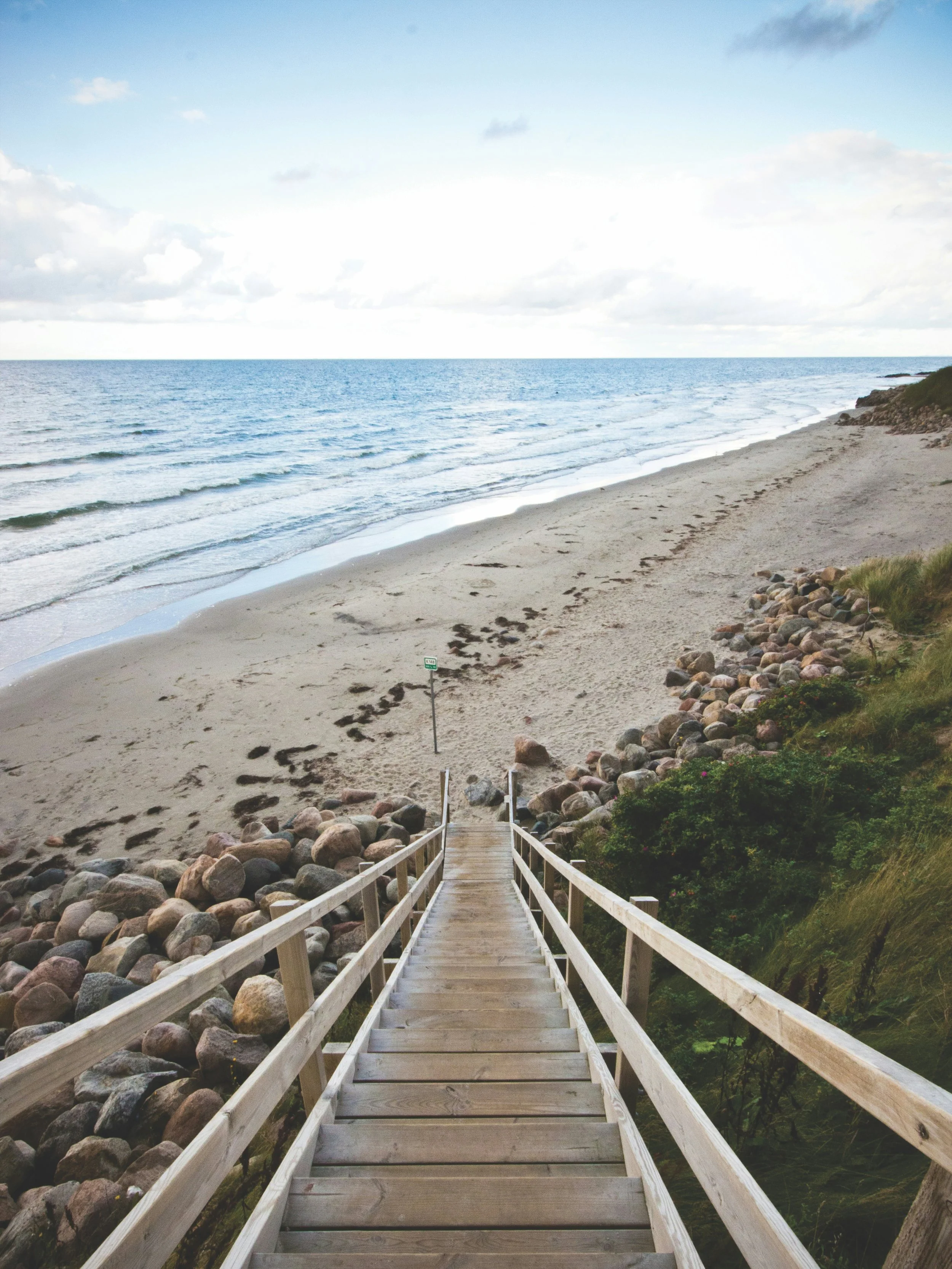 Wooden staircase leading to the beach, representing a clear marketing strategy that helps small businesses move toward long-term growth.