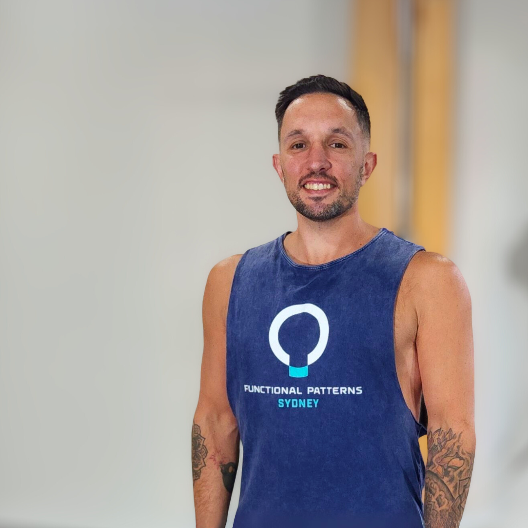 A man smiling and wearing a sleeveless navy blue shirt with a logo and text that reads 'Functional Patterns Sydney'