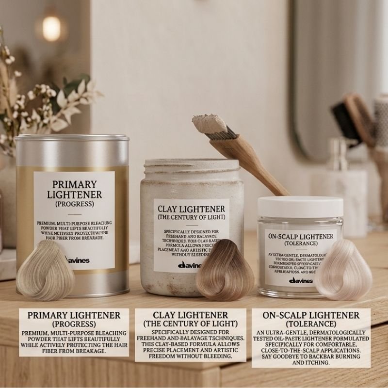 Three hair care products and two hair color samples on a wooden surface, with a mirror and blurred background.