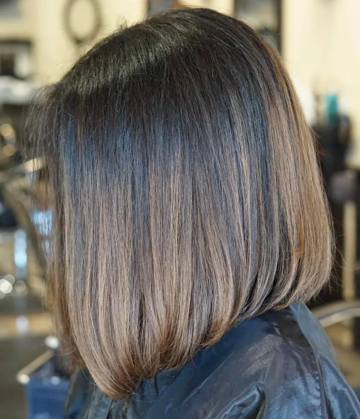 Woman with shoulder-length hair that is darker at the roots and gradually lightens to blonde at the tips.