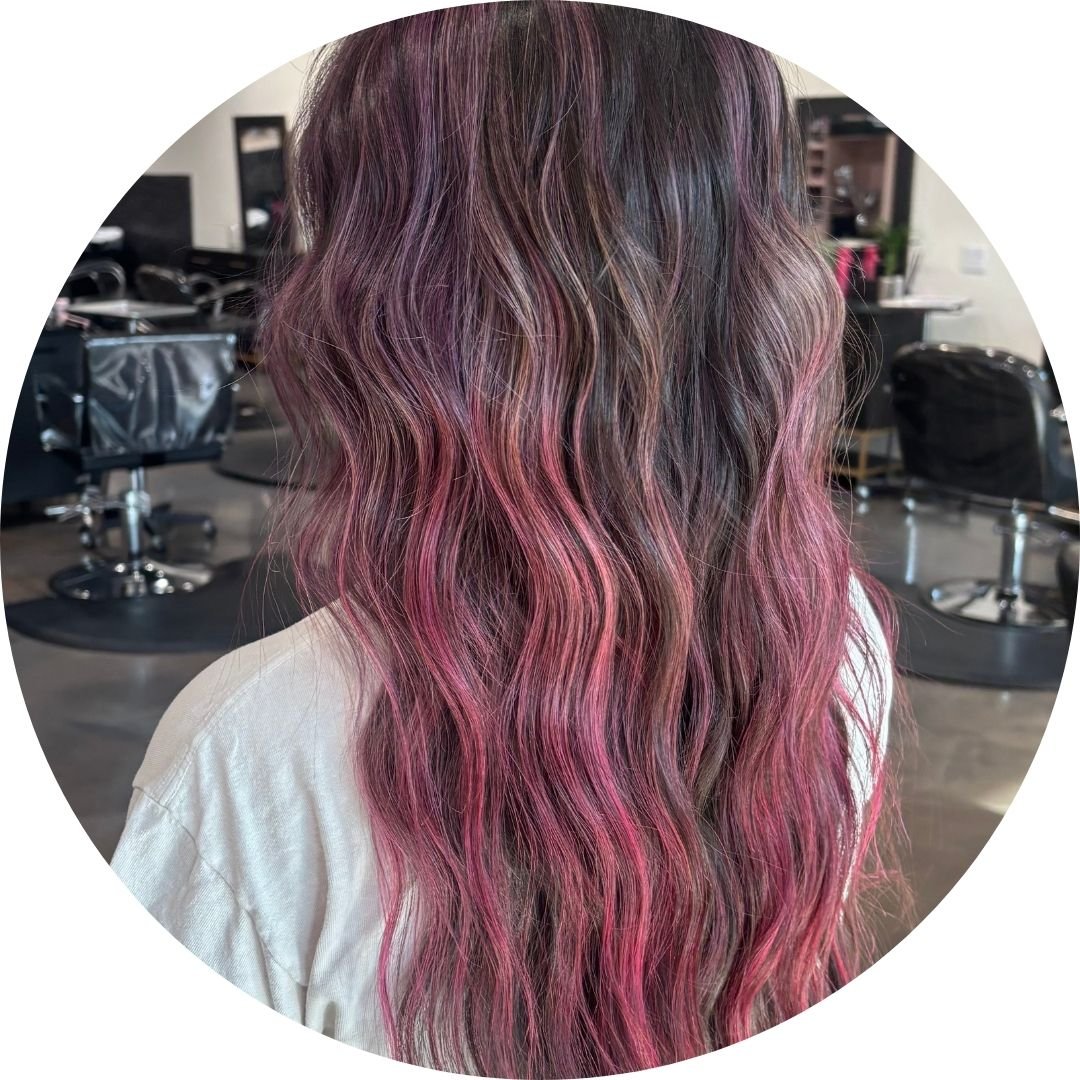 Wavy hair with a blend of brown and pink colors by a stylist at Spoleti Salon in Austin, Texas.