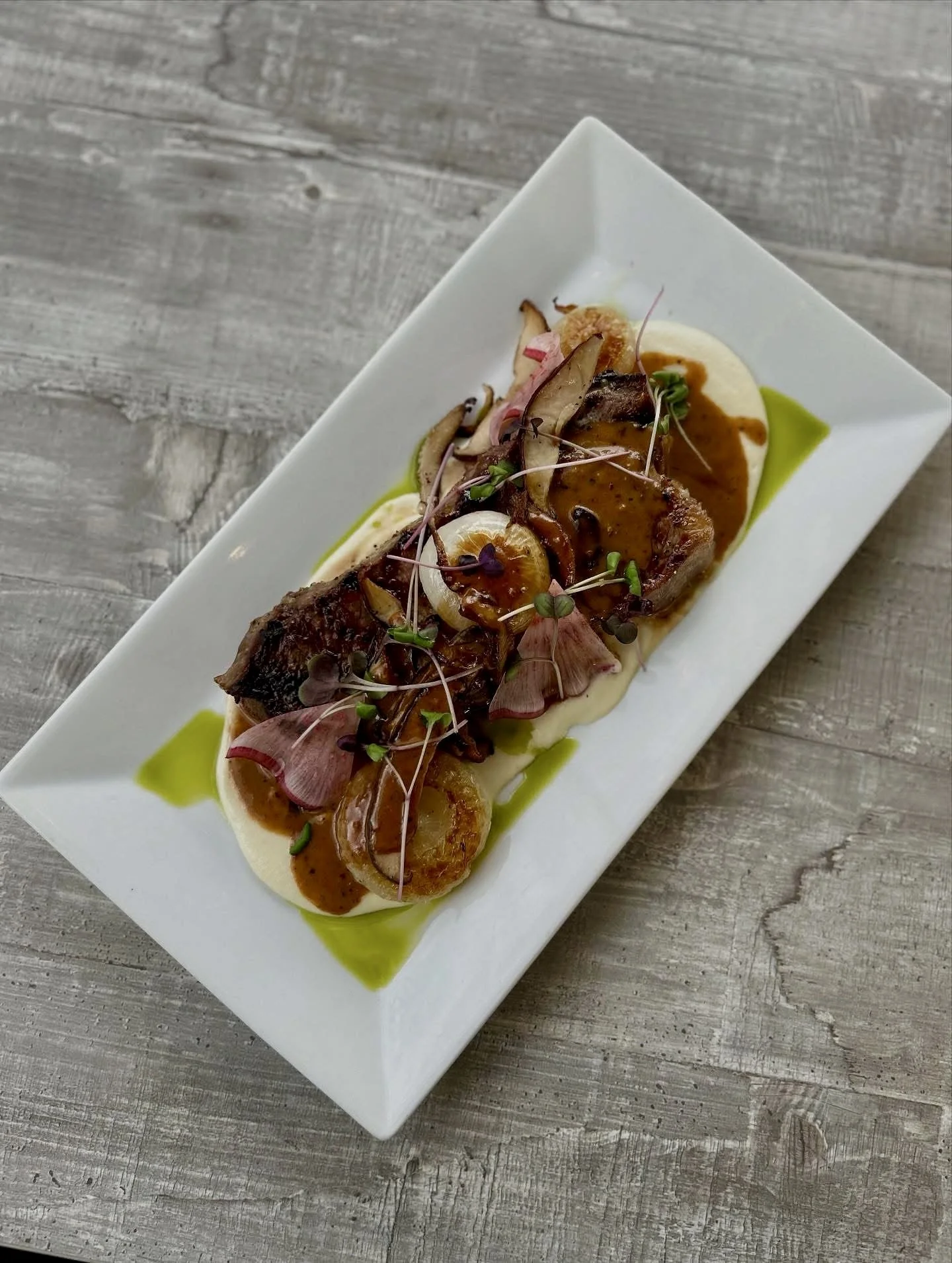 Pine Point Grill's sirloin au poivre, featuring an Angus NY strip, parsnip puree, cipollini onions, and shiitake mushrooms. 