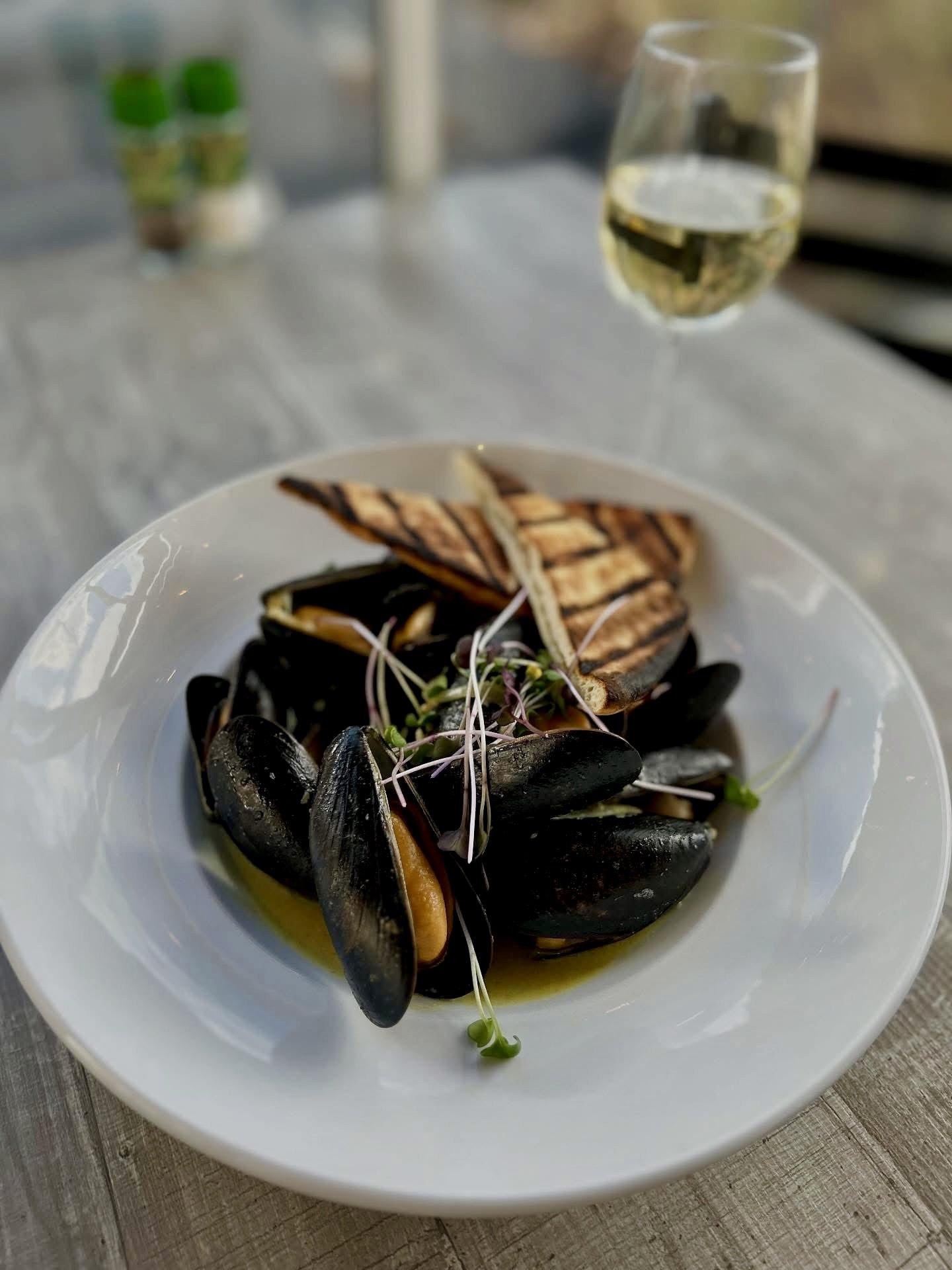 Pine Point Grill's coconut curry mussels featuring garlic, shallots, curry, fresh ginger, coconut milk, and warm naan bread.