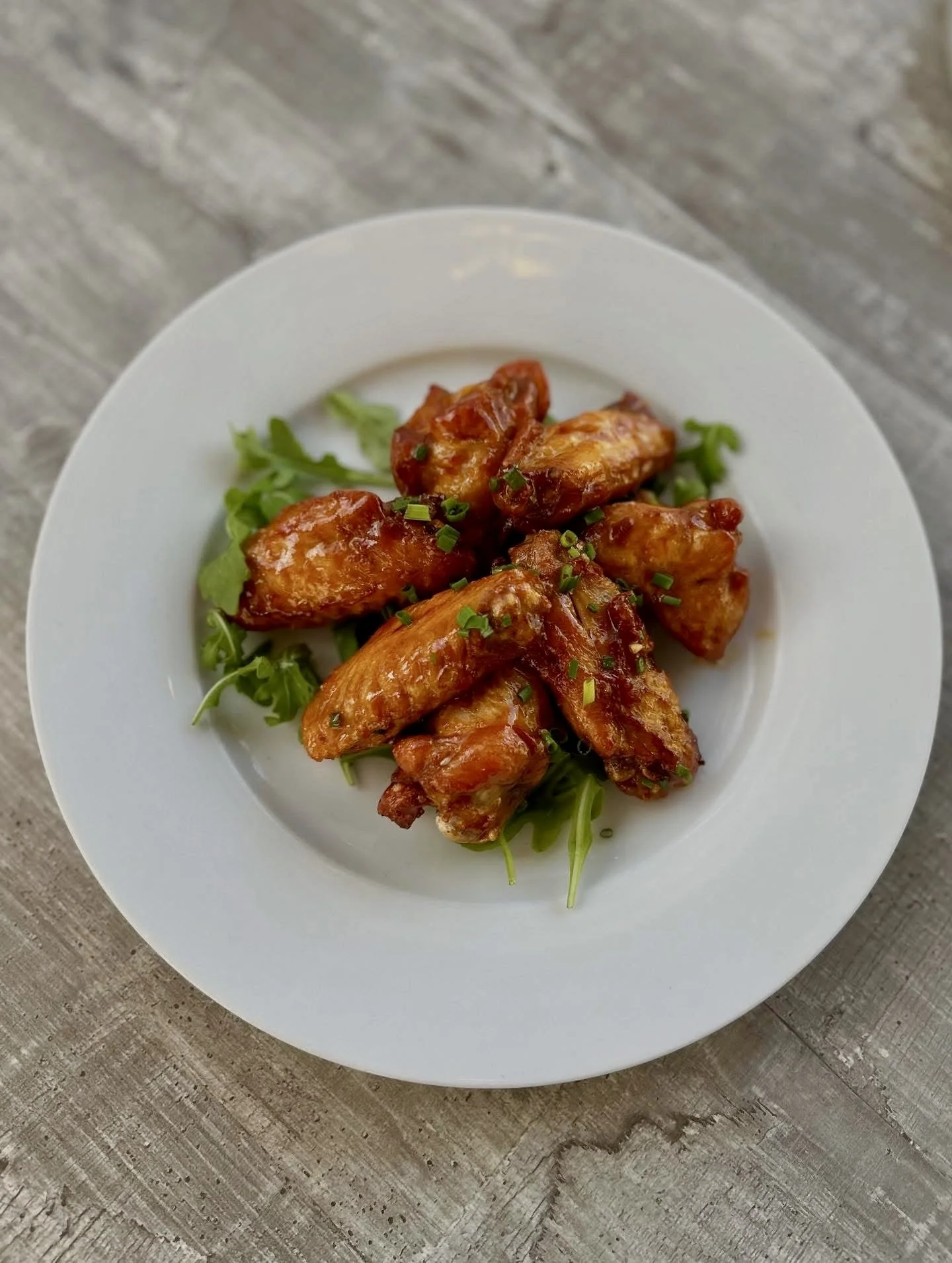 Pine Point Grill's maple sriracha wings with a sweet & spicy glaze and chives.