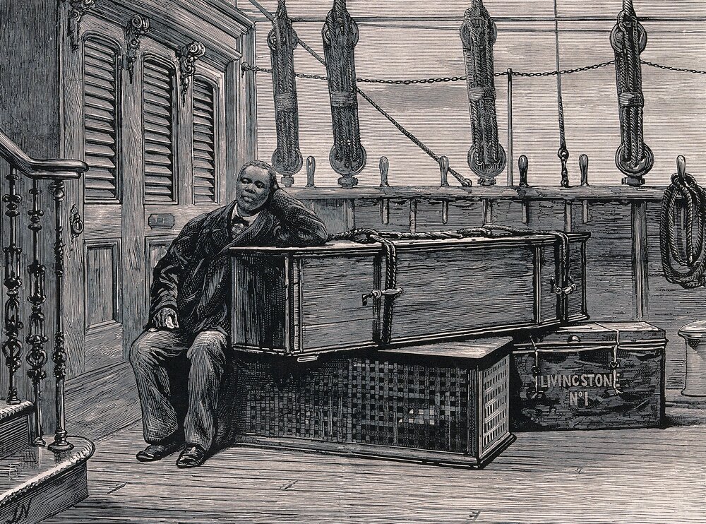 Jacob Wainwright sitting next to the coffin of David Livingstone on board ship. Wood engraving by J. Nash, after a photograph.