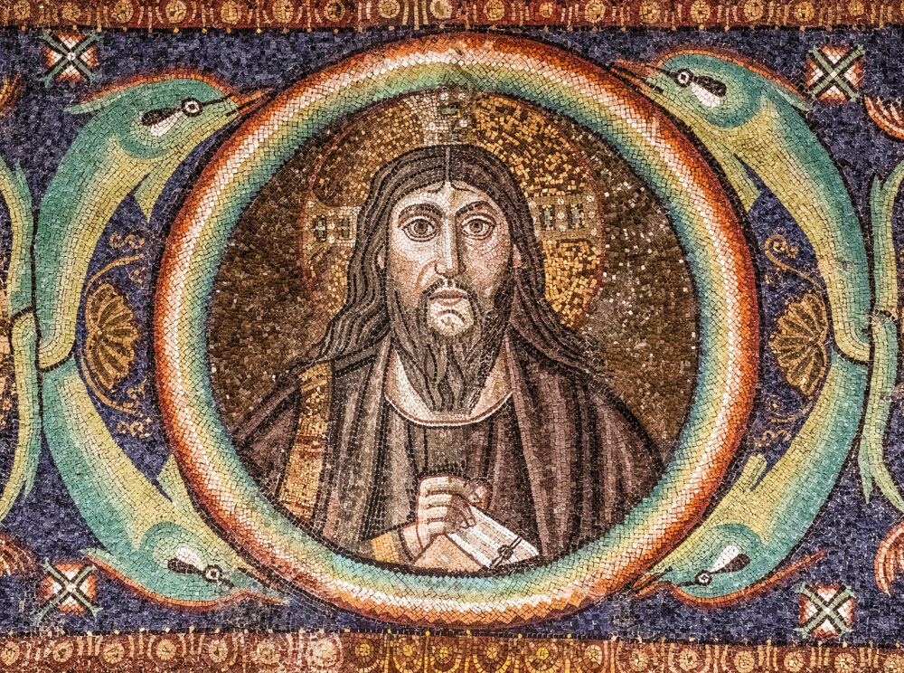 The mature bearded Christ holding the Gospel