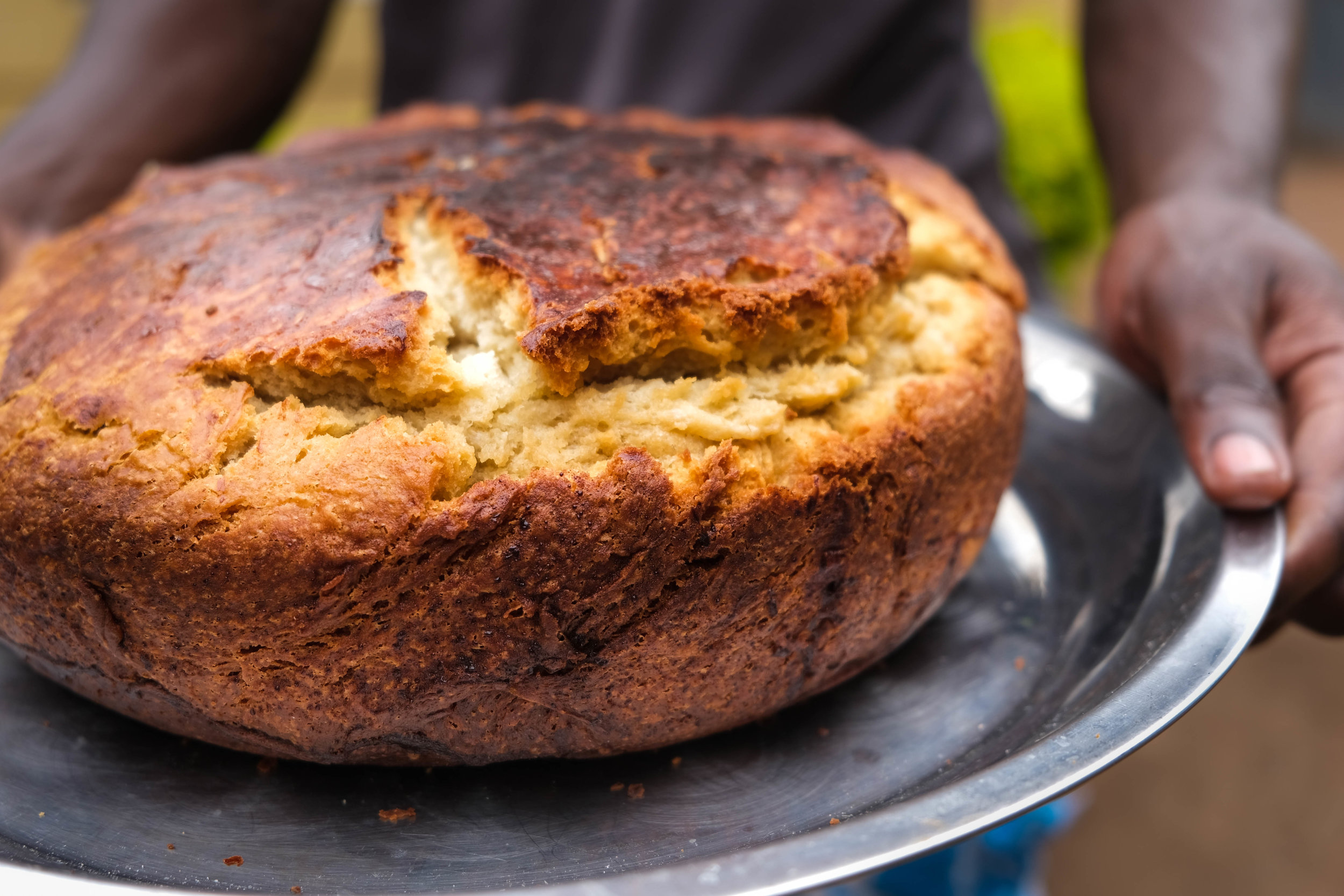  A Challah is freshly baked every week to celebrate Shabbat.  In many parts of  the world, Challah is a braided loaf of bread baked in an oven, but in Uganda, it is baked outside over charcoal and is equally delicious!   