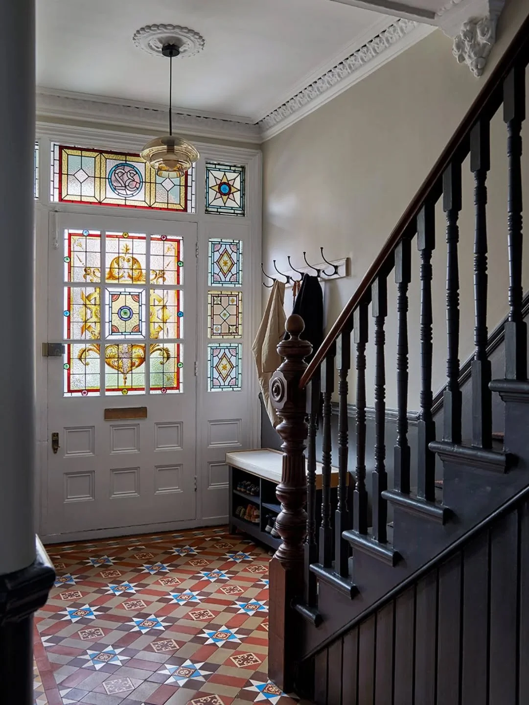 Hallways. At Huron Road, we retained some of the original period features such as the tiles and stained glass. The original mouldings were hidden under layers of paint. We were able to restore this. The stairs were repainted with @paintandpaperlibrar