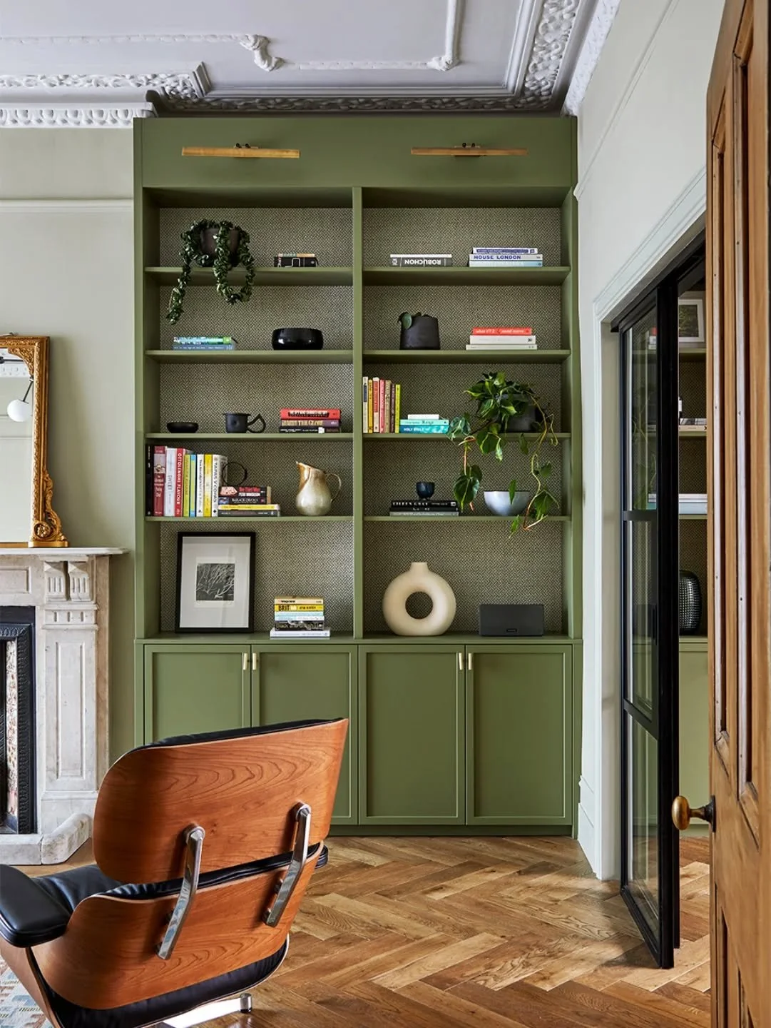 Bookcase love. This one is painted in Pan by @coatpaints with a wallpaper background by @phillipjeffries, to give it added depth.

What would be on your bookshelf?

#bookcase
#cabinetry
#green
#livingroom
#interiordecor
@tedtoddfloors 
@vitra
@eameso